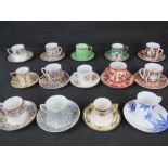 A collection of 14 coffee cans with saucers in different patterns by various makers,