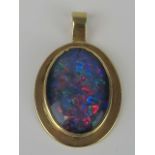 A 9ct gold and opal doublet pendant, large oval black backed opal in yellow gold mount stamped 9ct,