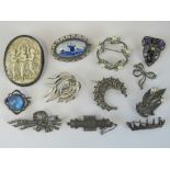 Twelve silver and white metal brooches including; delpht pottery plaque set in filigree frame,