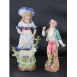 A Continental figurine if a lady and lamb (23.5cm high) together with another of a boy; a/f.