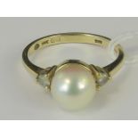 A 14ct gold pearl and diamond ring, central cultured pearl flanked by a pair of diamonds approx 0.