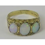 A 9ct gold opal ring, three graduated opals set in yellow metal carved head, shank hallmarked 375,