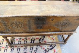 A 17TH.C.OAK PLANK COFFER ON A LATER STAND