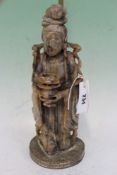 A CHINESE CARVED SOAPSTONE FIGURE OF A STANDING DEITY MOUNTED AS A LAMP.