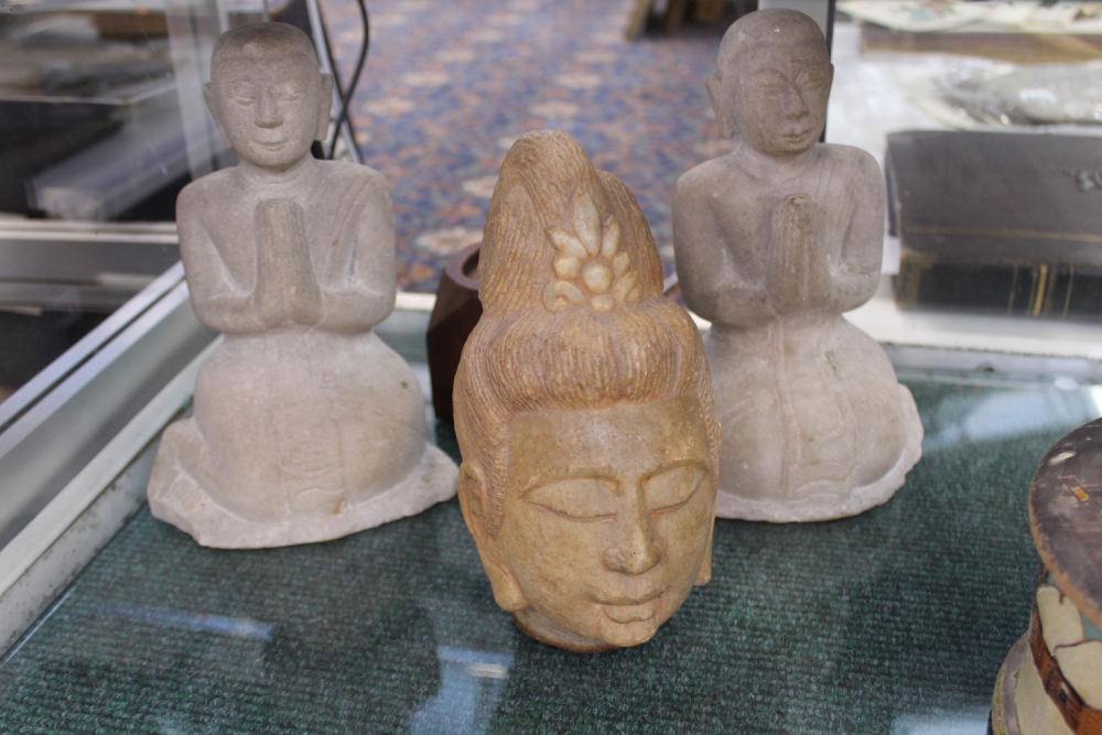 A PAIR OF CARVED MARBLE ORIENTAL FIGURES OF KNEELING DEITIES AND A CARVED STONE HEAD.