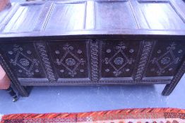 A 17TH.C.OAK COFFER WITH CARVED PANEL FRONT