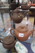 A GROUP OF FIVE ORIENTAL TERRACOTTA TEAPOTS SOME WITH FLORAL DECORATION.