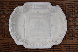 A TIN GLAZE PLATTER WITH RAISED ARMORIAL