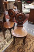 A PAIR OF LATE GEORGIAN MAHOGANY HALL CHAIRS WITH PAINTED ARMORIAL CRESTS