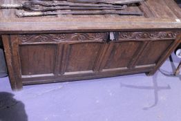 AN EARLY 18TH.C.OAK FOUR PANEL COFFER WITH FLORAL CARVED FRIEZE