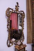 A LARGE CARVED GILTWOOD ROCCOCO STYLE MIRROR