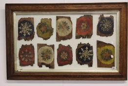 A GLAZED DISPLAY OF ANTIQUE NORTH INDIAN HAND PAINTED WOODEN TILES