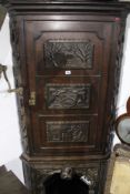 A 19TH.C.CARVED OAK CORNER CABINET ON STAND