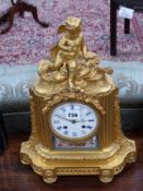 A Victorian gilt bronze mantle clock inset with painted porcelain panel, enamelled dial signed