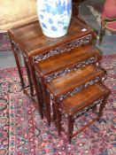 A nest of four Chinese carved hardwood tables with pierced foliate aprons