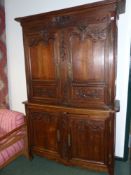 A French provincial Louis XV style carved oak two part cabinet