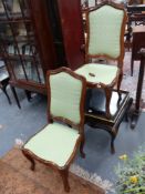 A pair of carved hall chairs with upholstered back panels in the Louis XV style