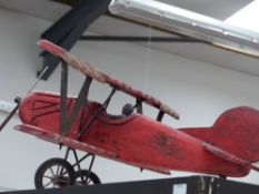 A wooden model of a vintage bi-plane with painted decoration