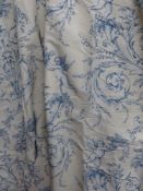 A pair of inter lined drapes with winged putti, foliate and floral designs in blue on a cream ground