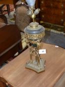 A gilt and patinated bronze urn with winged caryatid supports mounted as a lamp