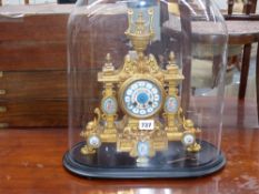 A Victorian gilt brass and porcelain mounted striking mantle clock on an ebonised base with glass