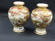 A pair of Japanese Satsuma baluster vases. Brocade collars above landscapes with figures,