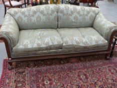 An early 20th.c.mahogany show frame settee with feather filled upholstery