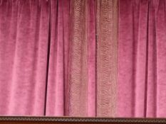 A pair of rose velvet inter lined drapes with patterned threaded gold borders rail and ties