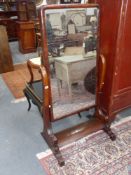 A Victorian mahogany cheval mirror on scroll arm supports