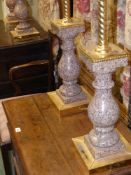 A set of four polished granite ormolu mounted table lamp bases