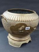 A Japanese bronze twin handle jardiniere decorated with panels of birds. Raised base with shaped