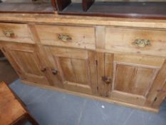 A Victorian pine dresser base with three drawers and cabinet doors
