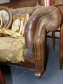 A Victorian Chesterfield settee with serpentine front and button leather upholstery for recovering