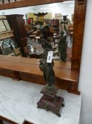 A pair of Antique patinated bronze figural candlesticks on shaped marble bases on paw feet, possibly