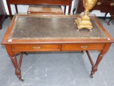 A late Victorian walnut writing table with brass gallery and leather inset top