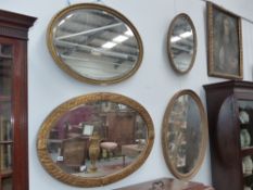 Four antique gilt framed oval wall mirrors