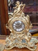 An antique cast brass case mantle clock with french striking movement, the case surmounted with