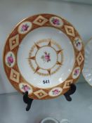 An early 19th Century Derby plate. Panels of roses with gilt surrounds and star form central