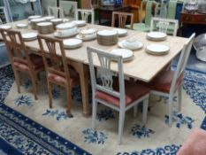 A large Continental pine draw leaf dining table together with twelve painted side chairs