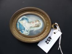 A 19th Century oval watercolour miniature portrait of a young lady. Empire style brass frame