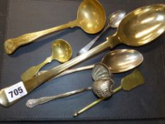 Seven various metal utensils to include a large brass basting spoon, a kings pattern ladle, etc