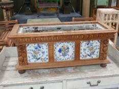 A Victorian carved oak and tile inset jardiniere