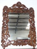 A decorative carved pine mirror with grape design frame