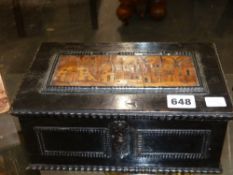 An early carved and ebonised Continental coffer with marquetry inlaid cityscape lid