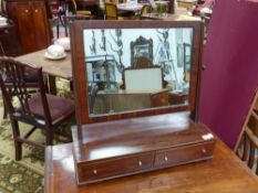 An early 19th.c.mahogany and boxwood strung swing mirror with two drawer base