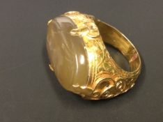 A Middle Eastern gold coloured ring with incised agate set intaglio depicting a winged horse.