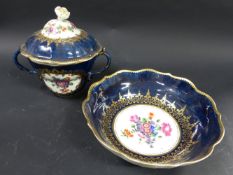 A Worcester two handled cup and cover. With matching saucer. Dark blue field with painted cartouches
