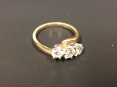 An 18ct three stone diamond cross-over ring