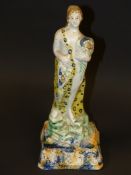 An early 19th Century Prattware figurine of Autumn or Plenty. On square blue and ochre base. 22cm