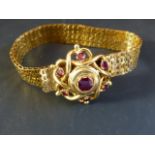 A late 19th Century gold coloured precious metal bracelet set with gem stones